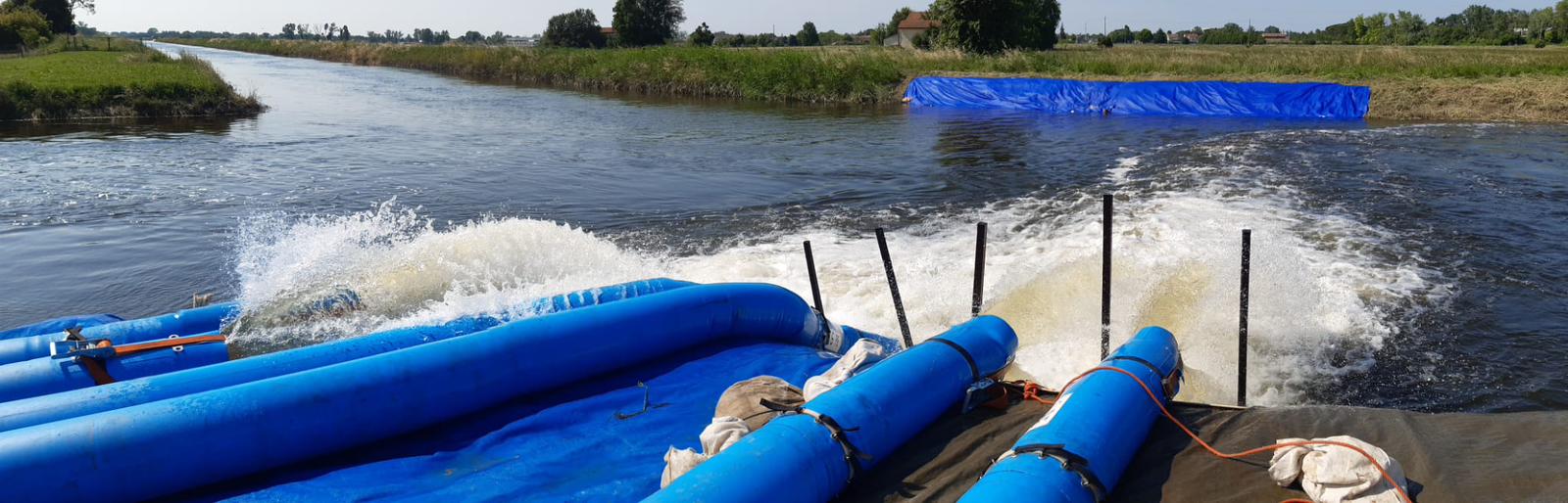 Large flood hose discharging over a barrier